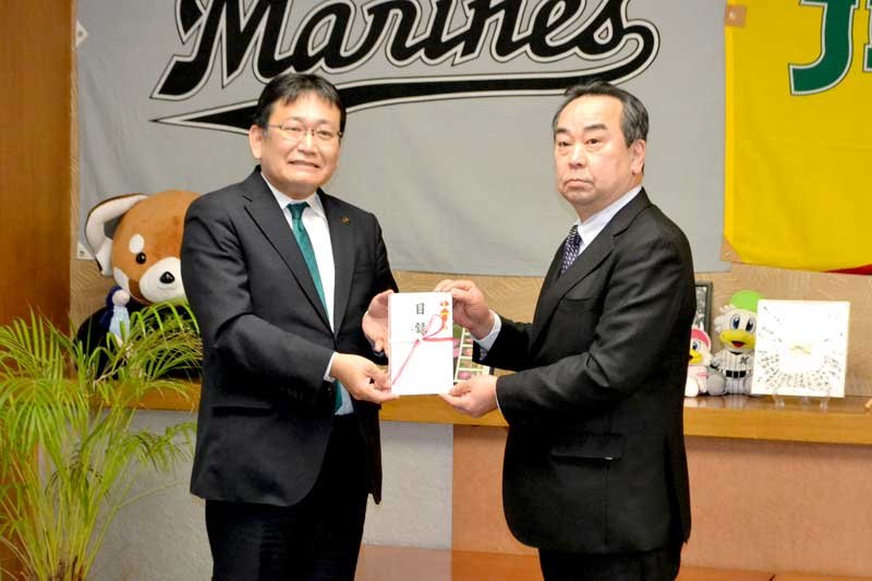 神谷市長（左）に目録を手渡す吉田理事長＝千葉市役所