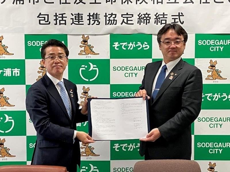 協定書を持つ古賀支社長（左）と粕谷市長＝袖ケ浦市
