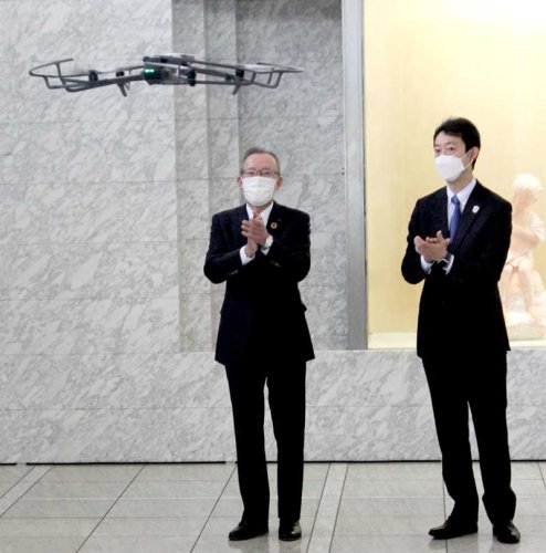 ドローンの実演飛行を見て拍手する熊谷頭取（左）と熊谷知事＝１日、県庁