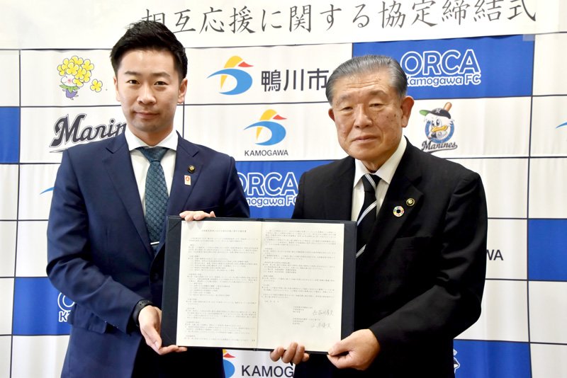 協定書を掲げる長谷川市長（右）と泉南市の山本市長＝鴨川市役所