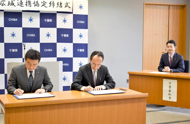 協定書にサインする（左から）習志野市の宮本市長、南房総市の石井市長。締結式には熊谷知事も出席した＝２８日、県庁