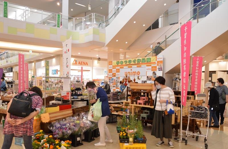 知的障害者による手作りの品に足を止める買い物客ら＝１９日、市原市
