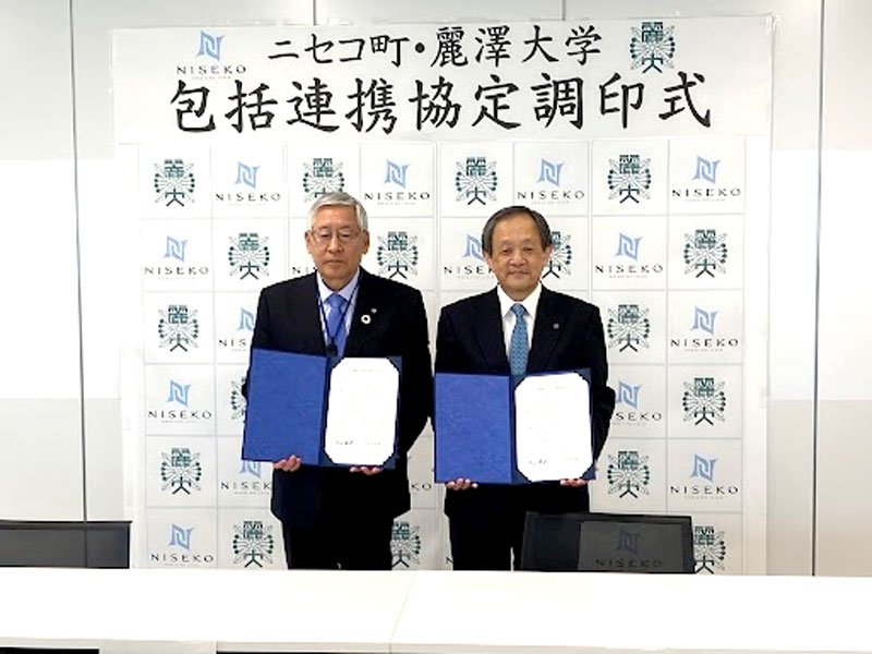 調印式に臨んだ片山町長（左）と堀内副学長＝ニセコ町（麗澤大提供）