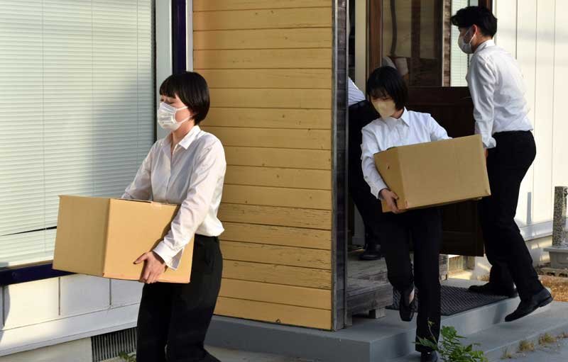 秋本衆院議員の地元事務所から押収物が入っているとみられる段ボールを運び出す東京地検の係官ら＝４日午後５時２５分ごろ、佐倉市