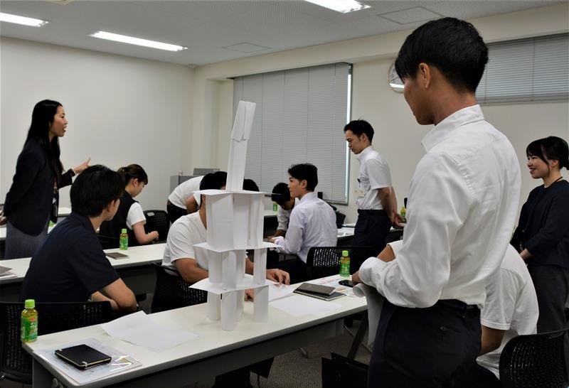 Ａ４用紙３０枚で紙のタワーを作るグループワークに参加する学生＝千葉市中央区