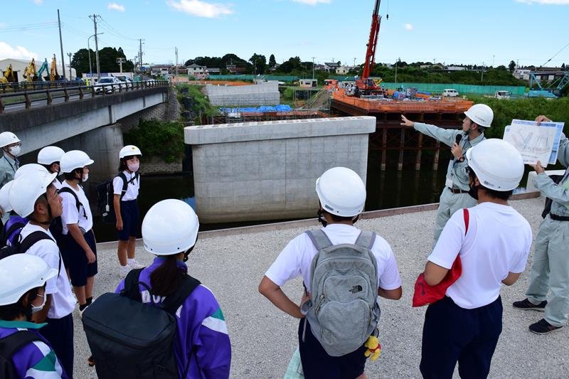 河道拡幅に伴う東橋の架け替え工事現場を見学する防災部の生徒たち＝茂原市と長生村の境を流れる一宮川

