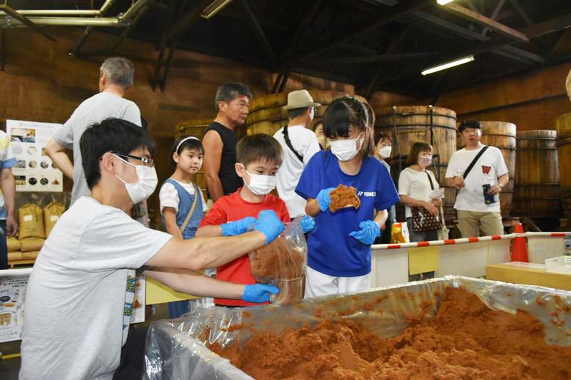 ヤマニ味噌の「蔵まつり」でみその詰め放題に挑戦する親子連れ＝２日、佐倉市並木町