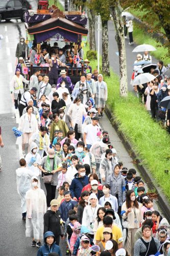 大通りの一部を交通規制し、山車を引き回した園児や地域住民ら＝２３日、成田市
