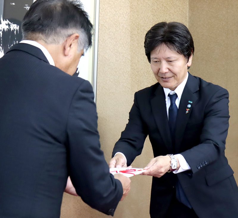 目録を手渡す井上氏（右）