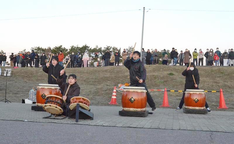 初日の出を待つ観光客の近くで太鼓を演奏する児童たち＝１日、九十九里町