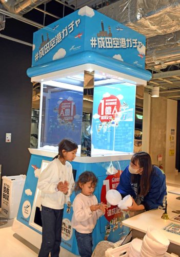 成田空港に登場した巨大ガチャに挑戦し、景品を獲得した子どもたち＝成田市