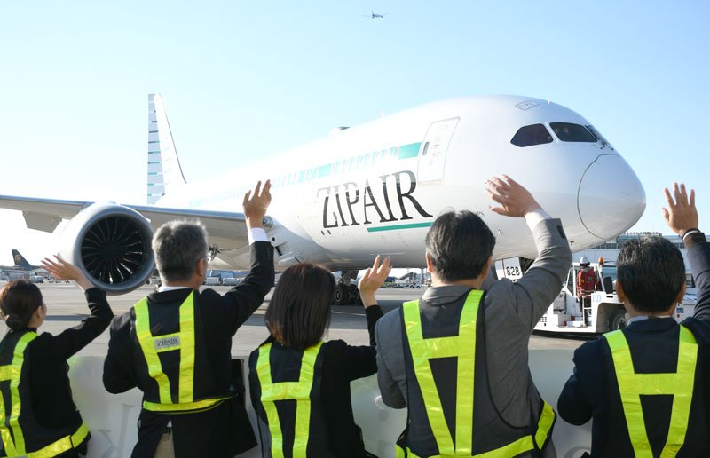 バンクーバーに就航する旅客機を見送るジップエアの社員ら＝１３日、成田市