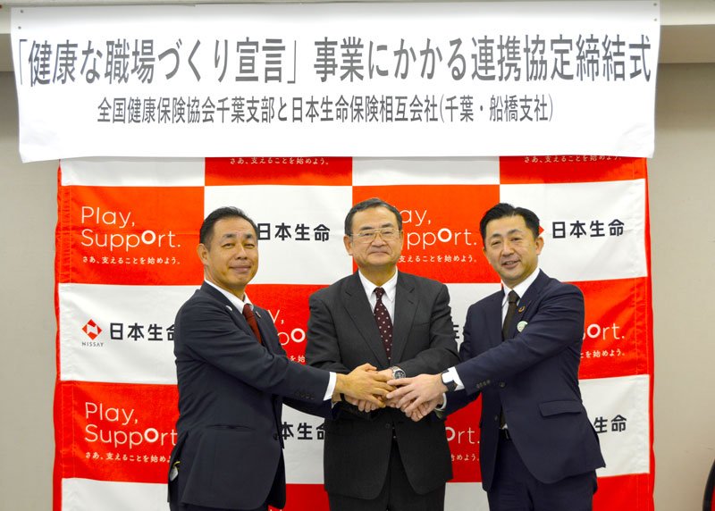 協定を締結して握手をする協会けんぽ千葉支部の佐藤信行支部長（中央）、星千葉支社長（左）、高見沢船橋支社長＝千葉市中央区