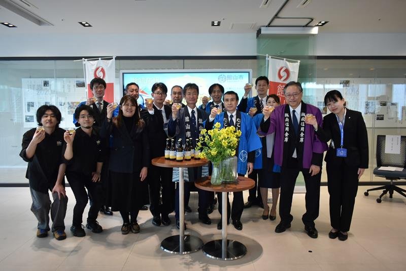 「菜の花エール」の誕生を喜ぶ川本理事長（右から２人目）ら＝都内
