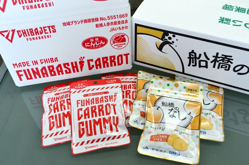 ジェッツとコラボした包装のニンジンのグミ（左）と、千葉工大生のデザインを取り入れた梨グミ包装