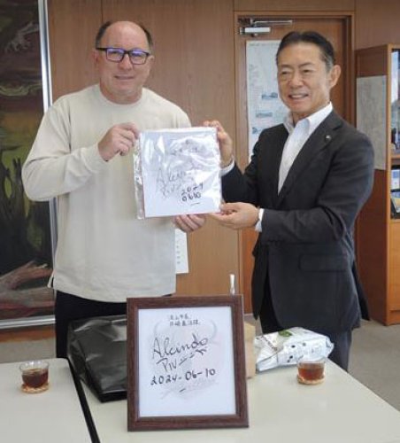 井崎市長（右）にサイン入り色紙を寄贈するアルシンドさん＝流山市