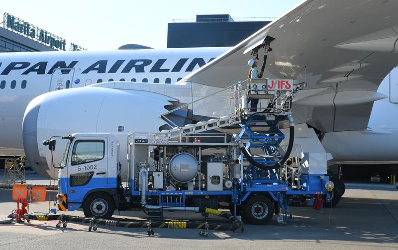 成田空港の駐機場で地中のバルブにつないだ特殊車両のホースから燃料を給油される航空機＝２０２３年７月、成田市（記事本文とは直接関係ありません）
