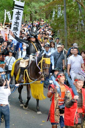 武者行列で手を振る本多忠勝役の渡辺正行さん＝１３日、大多喜町