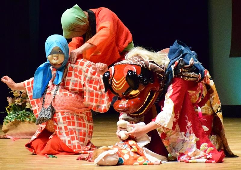 永田旭連の獅子舞。獅子が子どものおしめを替えている＝１９日、長生村文化会館
