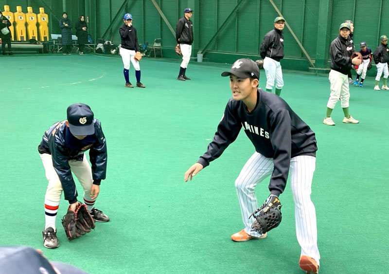小学生に守備を指導する千葉ロッテの早坂＝千葉市美浜区（球団提供）