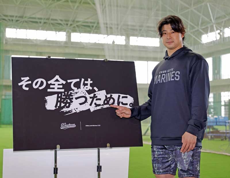 今季のスローガンが書かれたボードを指さすロッテ・藤岡＝３１日、沖縄県石垣市（共同）