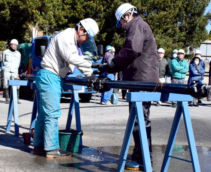 漏水した水道管を補修する訓練参加者＝８日、茂原市