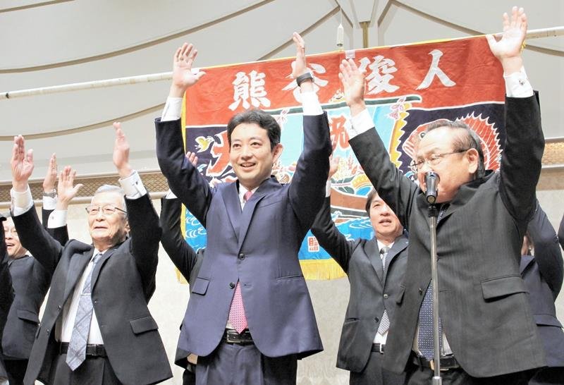 再選が確実となり、支持者らと万歳三唱する熊谷氏（中央）＝１６日、千葉市中央区