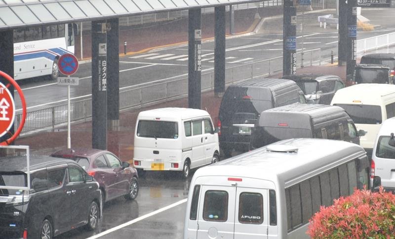縦列駐車する車で混雑する成田空港の乗降場。支柱に「駐停車禁止」との大きな表示もあるが、走行レーンにまで車があふれている＝２日午後、成田市（画像を一部加工しています）
