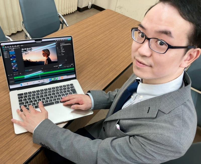 制作に使用したＰＣを手にする中澤さん＝１日、千葉市中央区
