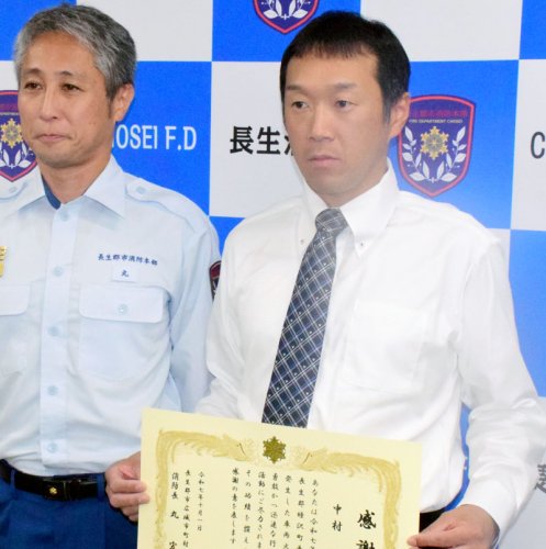 感謝状を持つ中村さんと贈呈した丸宏史消防長＝茂原市
