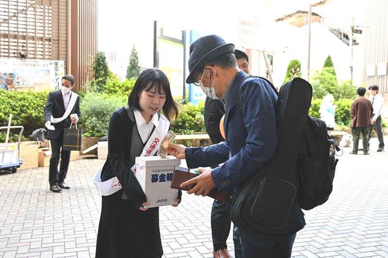 募金箱に寄付をする駅利用者＝１７日、千葉市中央区
