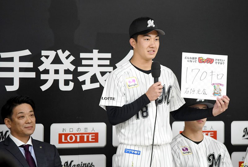 千葉ロッテマリーンズの新入団選手発表会で、色紙に「１７０キロ」と目標を書いて意気込みを語る石垣元気投手＝１１日、東京都新宿区のロッテ本社