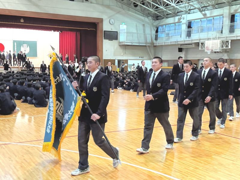 選抜旗を手に退場する専大松戸の高貝主将ら選手たち＝１６日、松戸市