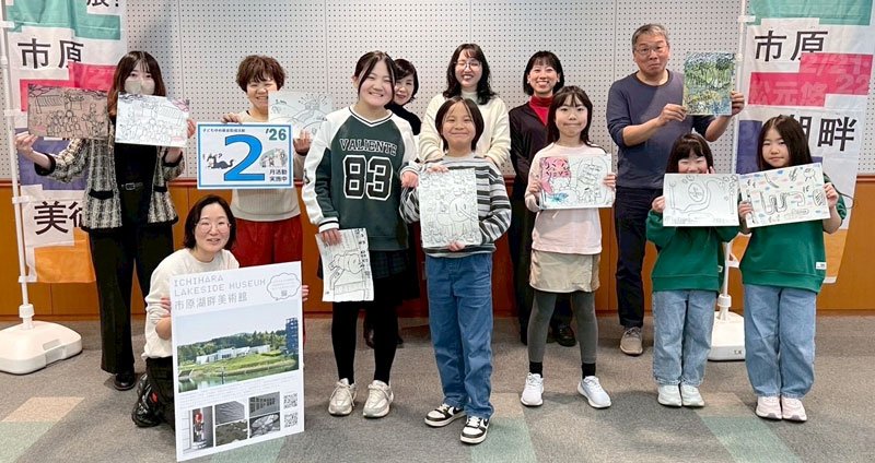 紙面から製作したリトグラフを掲げる参加者＝市原市立中央図書館
