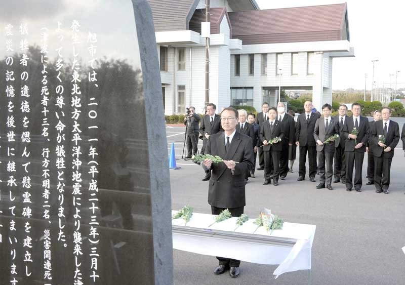 慰霊碑に献花する旭市の米本市長＝１１日午後２時４７分、同市のいいおかユートピアセンター駐車場
