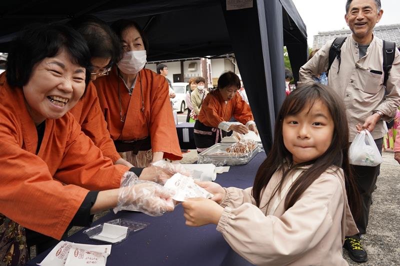 二十八市の名物「たけのころっけ」を手渡す葵の会メンバー（左）＝４月２９日、大多喜町
