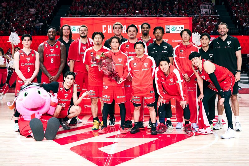今季限りで現役を引退する西村（中央）と記念写真に収まる千葉Ｊの選手ら＝３日、船橋市ららアリーナ東京ベイ（Ｂリーグ提供）