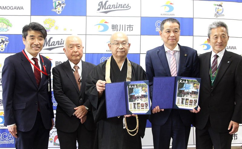 大山寺国指定重要文化財記念のオリジナルフレーム切手を見せる金本住職（左から３人目）、佐々木市長（同４人目）ら＝鴨川市