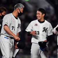 ９月１１日の楽天戦でプロ初完投し吉井コーチ（左）にねぎらわれる千葉ロッテ・小島＝ＺＯＺＯマリン