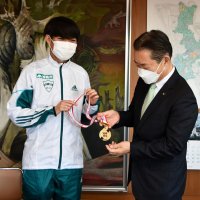 箱根駅伝総合優勝のメダルを井崎市長（右）に披露する中村選手
