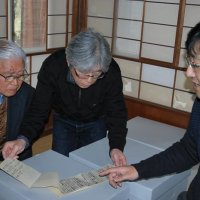 千葉大で整理した古文書を田丸家に返還する小関准教授（右）と説明を聞く田丸克也さん（左）＝２０１７年３月１３日、君津市