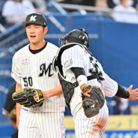 プロ初登板を無失点に抑えベンチに戻る千葉ロッテ・小沼（左）。捕手佐藤都
