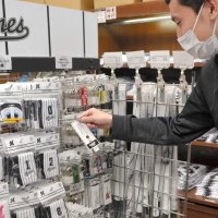 佐々木朗希投手のグッズが一部完売となり、「品切れ」の表示をつける店員＝１５日、千葉市美浜区のマリーンズストア海浜幕張駅前