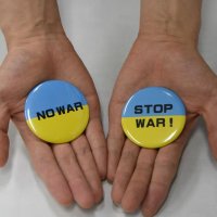 ウクライナ国旗を模した背景に、反戦のメッセージを書いた缶バッジ
