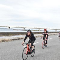 東京湾アクアラインをバックに海風を浴びながら駆け抜ける参加者＝木更津市