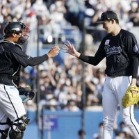 完全試合を達成し、捕手の松川（左）からウイニングボールを受け取る佐々木朗。１３者連続奪三振の新記録も樹立した（共同）