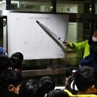 惑星の位置関係を児童に説明する小倉さん
