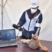 コククジラの骨の形状を３Ｄスキャナーで読み取る生徒
