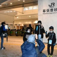 シャッターが開いた幕張豊砂駅で記念撮影する子どもたち＝１８日午前４時２５分ごろ、千葉市美浜区