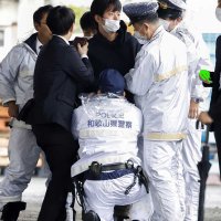 岸田首相が衆院和歌山１区補欠選挙の応援演説に訪れた和歌山市の雑賀崎漁港で、発煙筒のようなものを投げ込み取り押さえられる男（中央上）＝１５日午前１１時２８分（共同）